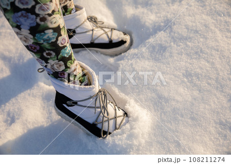 A woman walks on a thick layer of fresh snow. 108211274