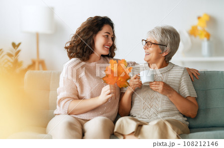 woman and her senior mother with autumn leaves woman and her senior mother with autumn leaves 108212146