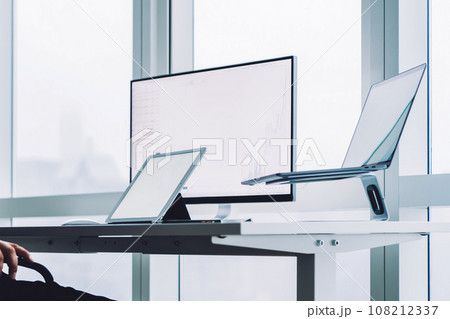 Pensive man with devices at office desk 108212337