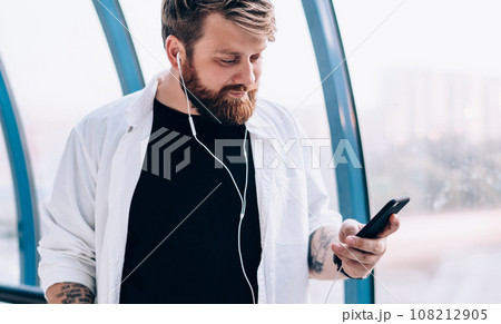 hipster guy received reading sms and choosing player song 108212905