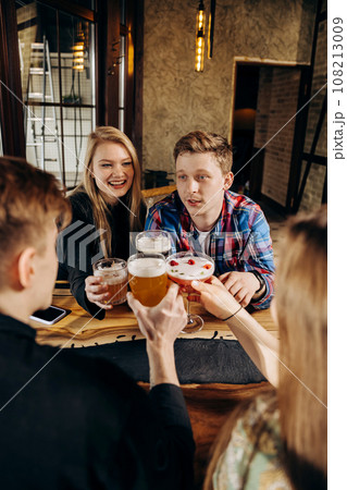 Happy group of friends drinking and clinking with beer and cocktails at brewery bar restaurant Happy group of friends drinking and clinking with beer and cocktails at brewery bar restaurant 108213009