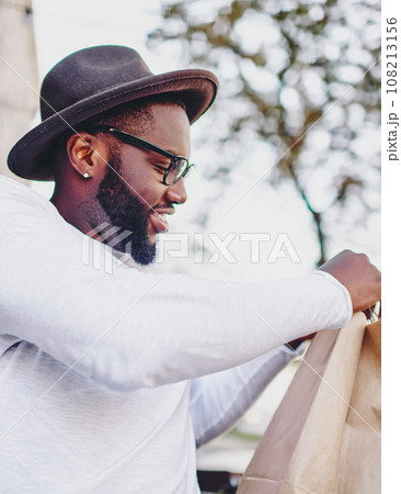 Happy black shopaholic feeling excited from spending day for shopping satisfied with bought things 108213156