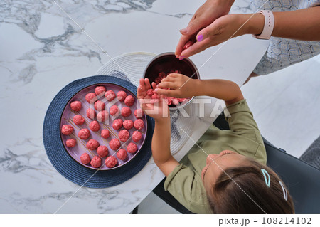 Grandmother and granddaughter preparing meatballs. Grandmother and granddaughter preparing meatballs. 108214102