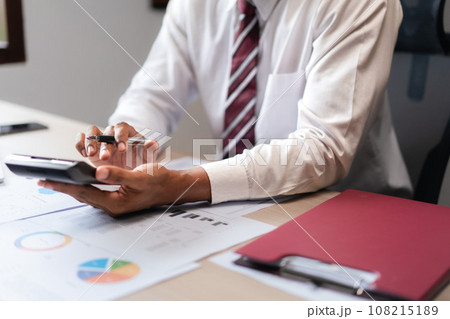 Businessman use calculator to calculate cost of project and checking marketing document of startup 108215189