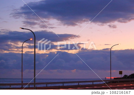 海に沈む夕日と海岸沿いの道 海に沈む夕日と海岸沿いの道 108216167