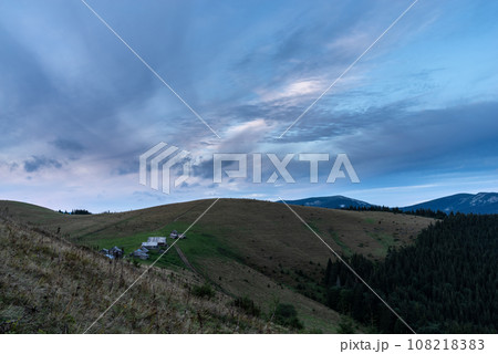 Morning landscape in the mountains. Dawn in the mountains. Rural huts on top of the mountain. Cloudy sky over the village. Morning landscape in the mountains. Dawn in the mountains. Rural huts on top of the mountain. Cloudy sky over the village. 108218383