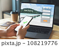 Hand using laptop and booking hotel on website for vacation after a long work and payment completed 108219776