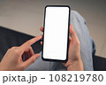 Hand holding black smartphone with blank screen for graphic display montage  108219780