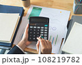 Accountant using calculator with financial documents on desk office. 108219782