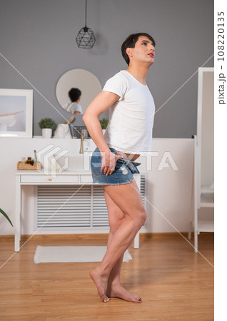 The man is wearing makeup. Transgender posing in the studio. 108220135