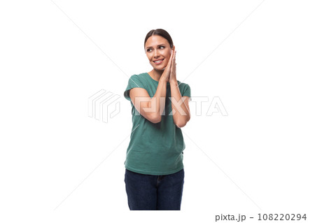 young woman with black hair and a slim figure dressed in a green T-shirt posing on a white young woman with black hair and a slim figure dressed in a green T-shirt posing on a white 108220294