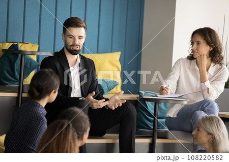 Serious handsome young business professional speaking to colleagues 108220582