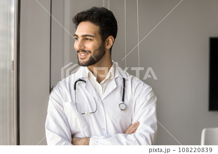 Positive successful Arab doctor man standing at window 108220839