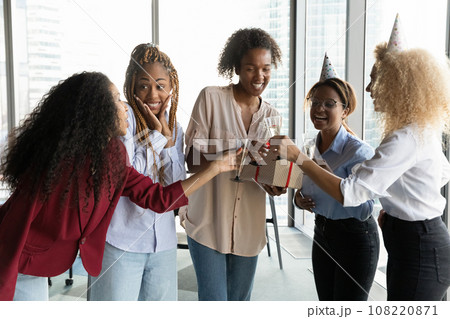Excited African American businesswomen celebrating colleague birthday in office 108220871