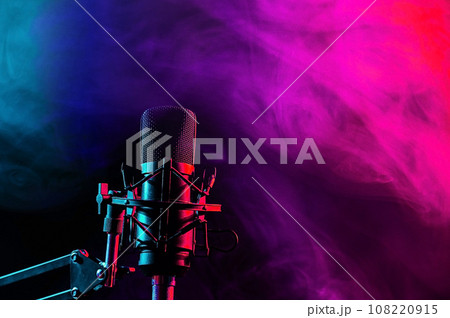 Professional microphone in pink smoke on a black background. Professional microphone in pink smoke on a black background. 108220915