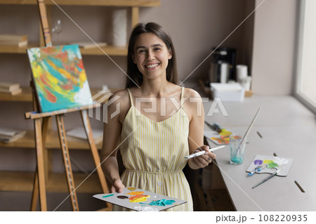 Painter woman hold palette and paintbrush smile look at camera Painter woman hold palette and paintbrush smile look at camera 108220935