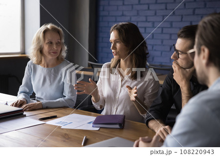 Attractive young businesswoman talking to partners at meeting 108220943
