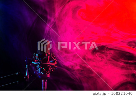 Professional microphone in red blue smoke on a black background. Professional microphone in red blue smoke on a black background. 108221040