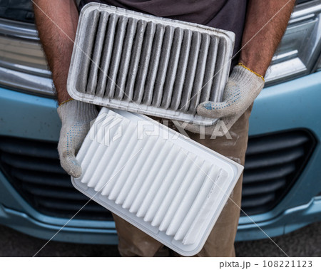 The master changes the air filter in the car engine. The master changes the air filter in the car engine. 108221123