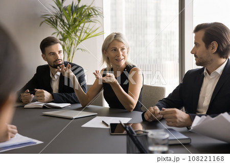 Positive confident mature business woman speaking to younger project partners Positive confident mature business woman speaking to younger project partners 108221168