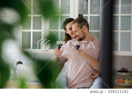 Happy cute young dating couple drinking wine, hugging 108221282