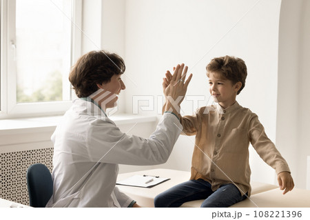 Smiling man doctor gives high five to little kid 108221396