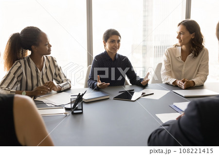 Pretty young Indian business leader woman talking to partners Pretty young Indian business leader woman talking to partners 108221415