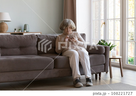 Focused elder 80s woman using online service, medical app Focused elder 80s woman using online service, medical app 108221727