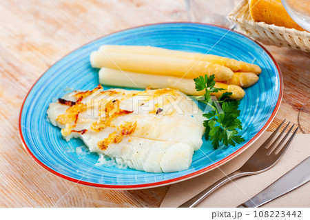 Deliciously roasted halibut fillet with asparagus and greens 108223442