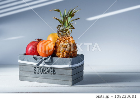 Fresh fruits in grey wooden box with inscription Storage. Fresh fruits in grey wooden box with inscription Storage. 108223681