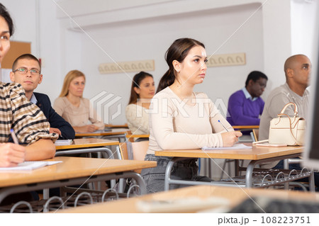 Young woman studying with colleagues at classroom 108223751