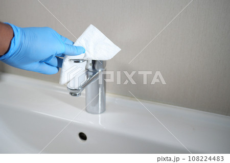 hand in gloves cleaning tap and washbasin, 108224483