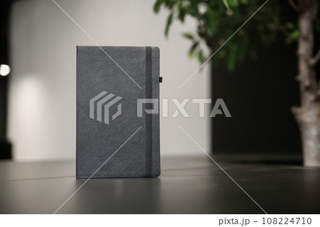 Hard covered black sketchbook on wooden table. Blank stationery mockup. Template for placing your design. Hard covered black sketchbook on wooden table. Blank stationery mockup. Template for placing your design. 108224710