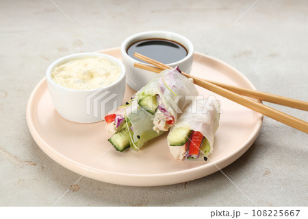 Delicious rolls wrapped in rice paper served on light grey table 108225667