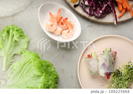 Flat lay composition with delicious rolls wrapped in rice paper on light grey table Flat lay composition with delicious rolls wrapped in rice paper on light grey table 108225668