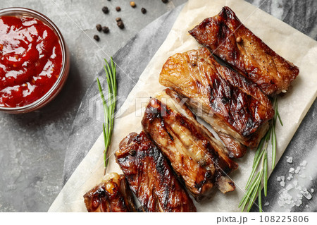 Delicious grilled ribs served on grey table, flat lay 108225806