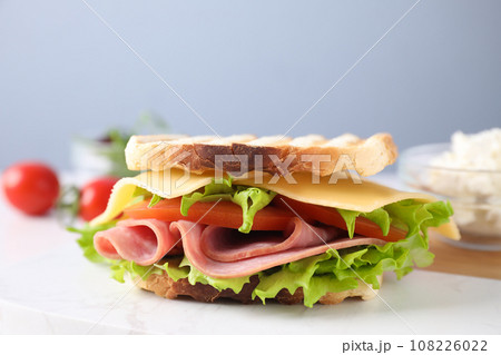 Tasty sandwich with ham on white marble table, closeup 108226022