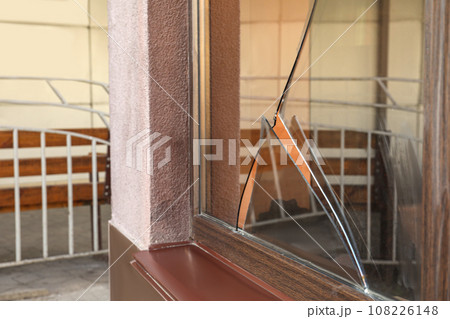 Broken window with sharp smithereens outdoors. Requiring repair Broken window with sharp smithereens outdoors. Requiring repair 108226148