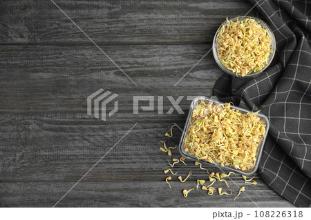 Flat lay composition with sprouted green buckwheat on dark wooden table, space for text Flat lay composition with sprouted green buckwheat on dark wooden table, space for text 108226318