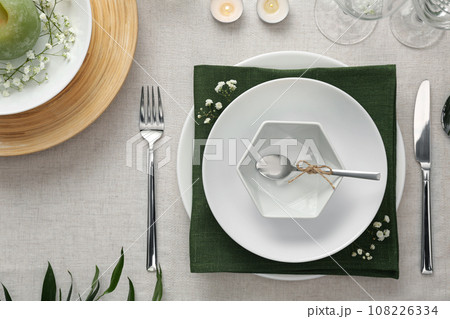 Elegant table setting with green plants on light cloth, flat lay 108226334
