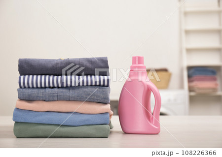 Stack of fresh laundry and detergent on white table in bathroom Stack of fresh laundry and detergent on white table in bathroom 108226366