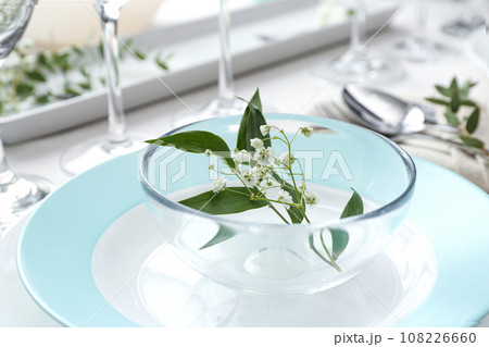 Stylish tableware with leaves and flowers on table, closeup. Festive setting 108226660