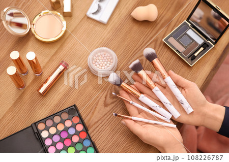 Beauty blogger with set of makeup brushes at table, closeup 108226787