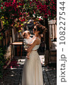 A stylish woman with a baby in her arms on the background of a street in Turkey. A baby in his mother's arms. A beautiful portrait of a child in the arms of his mother. A woman with a baby 108227544