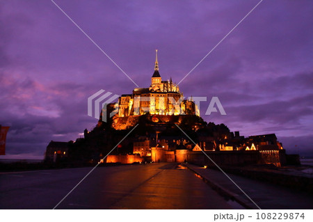 フランス　ノルマンディー地方のサンマロ湾に浮かぶ夕闇の小島に建つ世界文化遺産の修道院モンサンミシェル 108229874