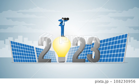 Vision businessman uses binoculars on 2023 light bulb powered by solar cells. 108230956