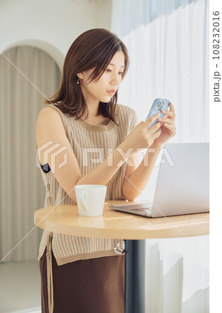 スマホとパソコンで仕事をする女性 108232016