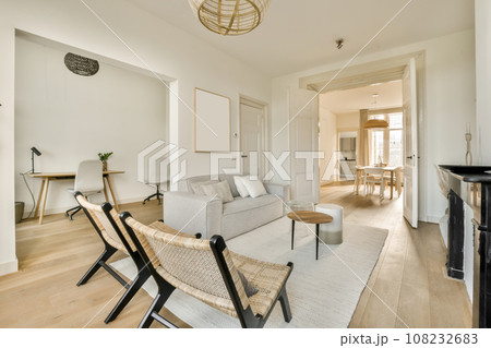 a living room with white walls and wood flooring there is a grey couch in front of the gray sofa 108232683