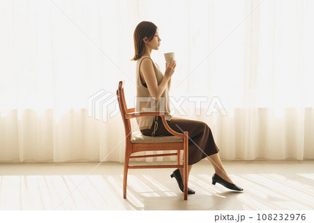 窓際でコーヒーを飲む女性 108232976