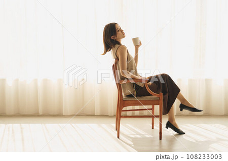 窓際でコーヒーを飲む女性 108233003